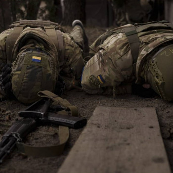 Due soldati ucraini si riparano dal fuoco russo a Irpin, alla periferia di Kievss